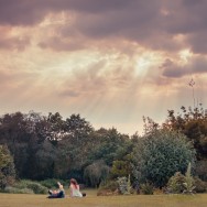 two people lie on the grass bathing in the rays of the golden sun.