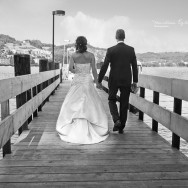 Newly wed's walk along a pier.