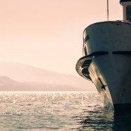 A ship on a lake that is illuminated by the setting sun.