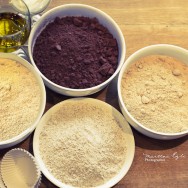Four bowls full of flour, ground hazelnuts, sugar and cacao powder.