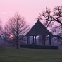 The setting sun and a silhouette of a pavilion.