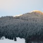 A sunset behind a snow covered mountain.