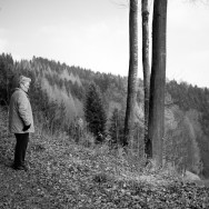 A woman stands still on a mountain ridge, deep in thought.