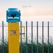 Beach-side binoculars overlooking a sunset.