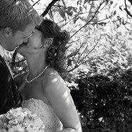 Newlyweds kiss each other.