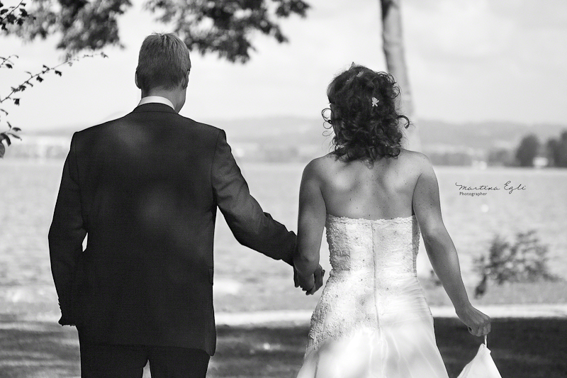 Hand in Hand Newlyweds walk hand in hand towards a lake