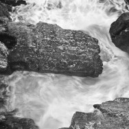 Water is swirling around a rock.