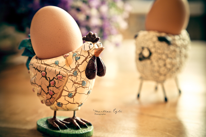 A boiled egg in an eggcup in the shape of a chicken