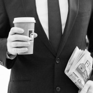A b&w image of a man in a suit holding a coffee to go and the financial times.