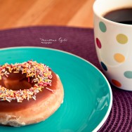A cup of coffee and a doughnut.