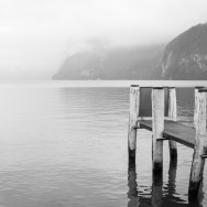A jetty leading onto a misty lake in Switzerland.