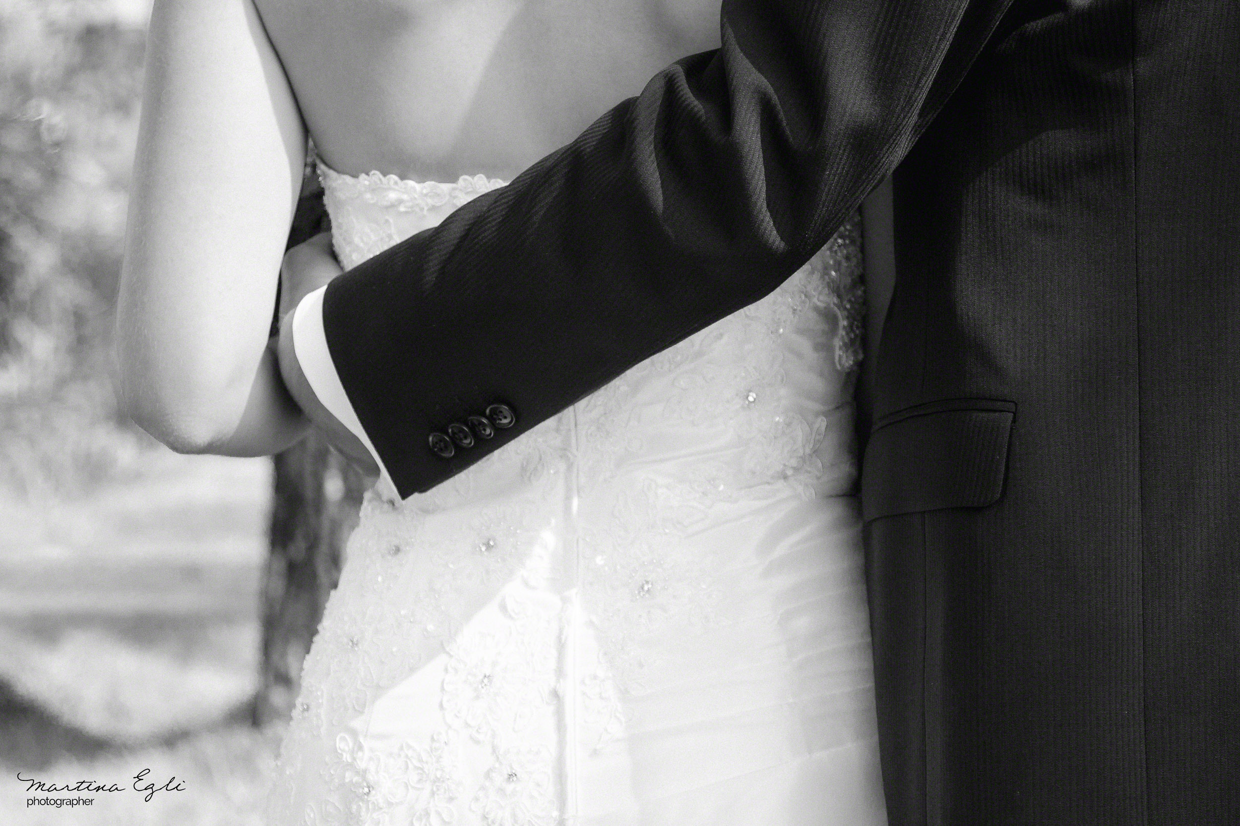 A groom puts his arm around his Bride