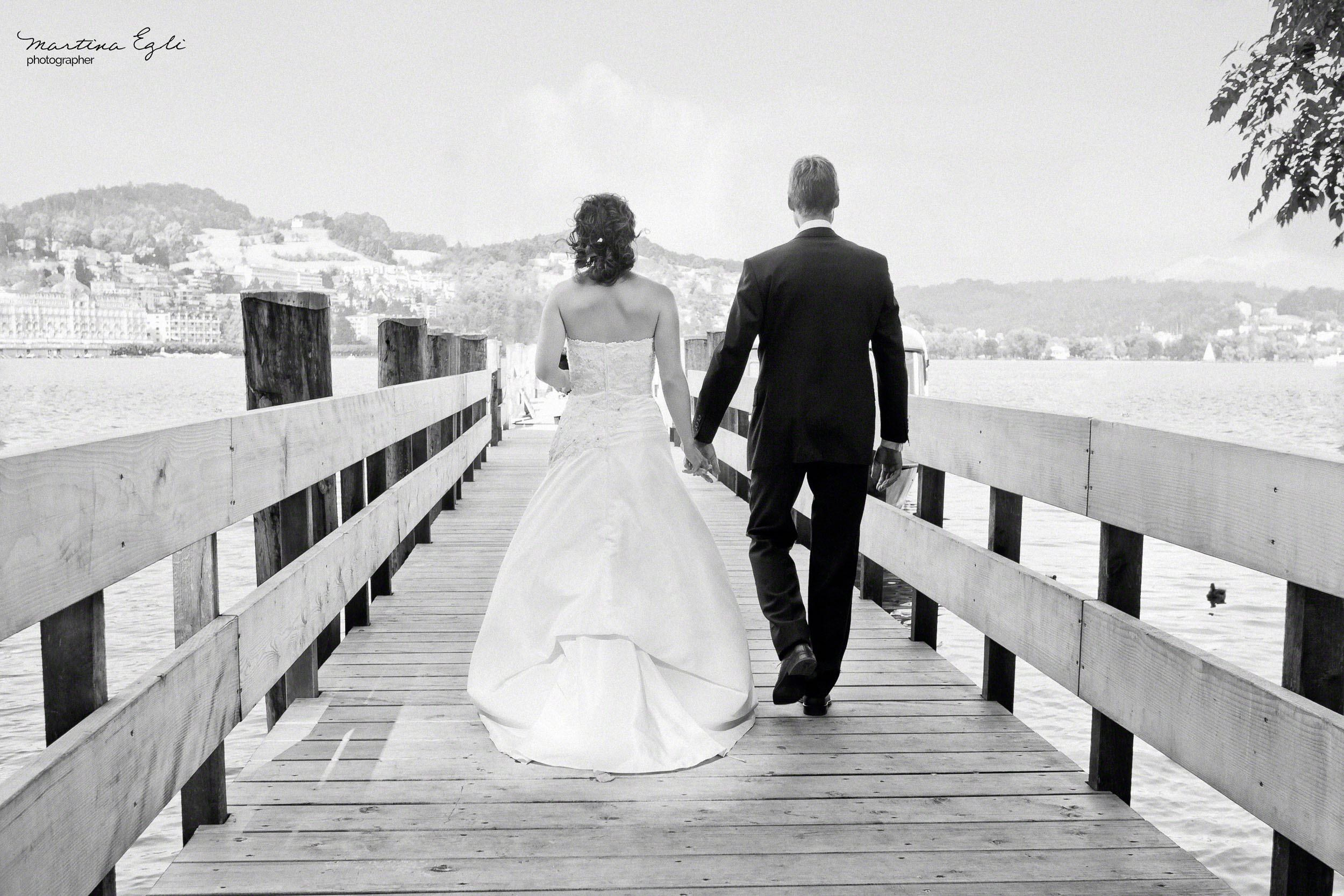 A Bride and Groom walk along a pier