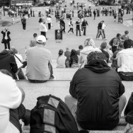 People sitting on the steps of Trafalgar Square in London.