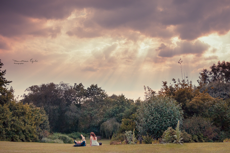 Two people lying on the grass bathing in the rays of the golden sun.