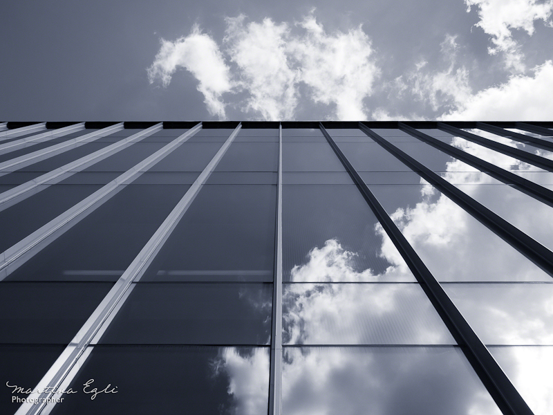 Blue Image of clouds reflected in a glass building