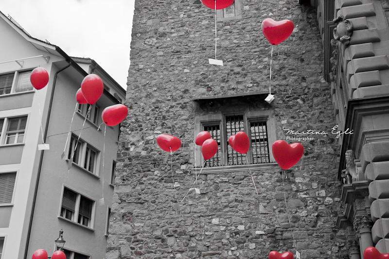 Heart shaped balloons float through the air.