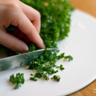 Person cutting Parsley on a chopping board