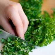 Person cutting Parsley on a chopping board