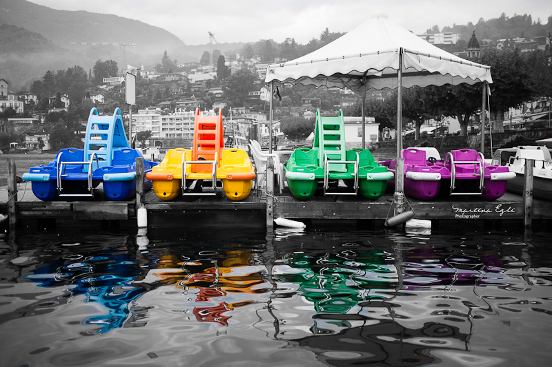 Four pedalos on a lake.