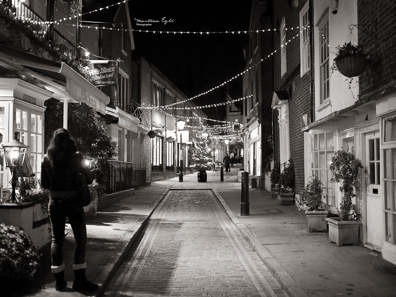 A street decorated with christmas lights.