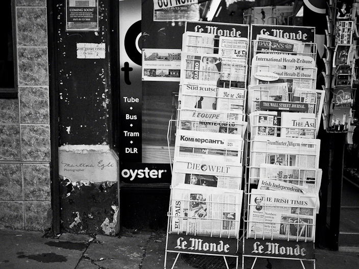 A newspaper stand filled with newspapers from all over the world.