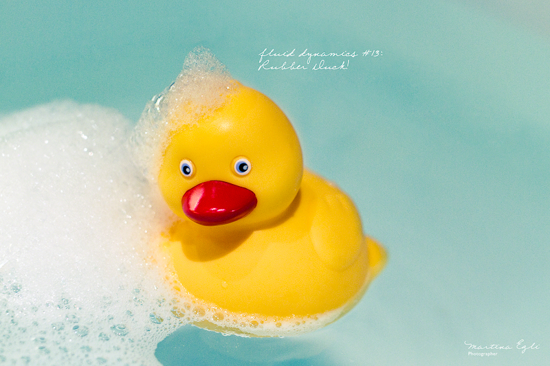 A rubber duck with bubbles on his head.