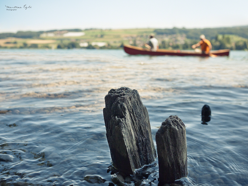 Canoeists glide into the frame of a landscape.