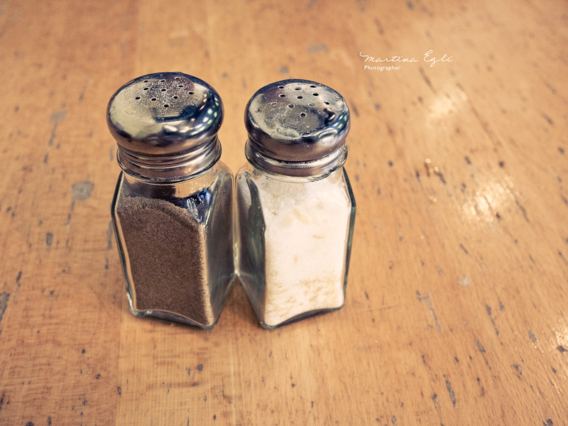 Salt and pepper shaker on a wooden table.