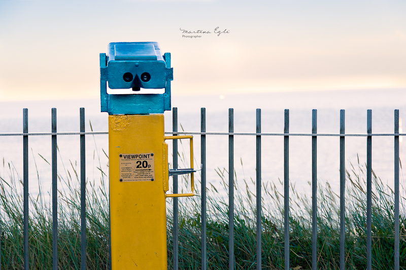 Beach-side binoculars overlooking a sunset.