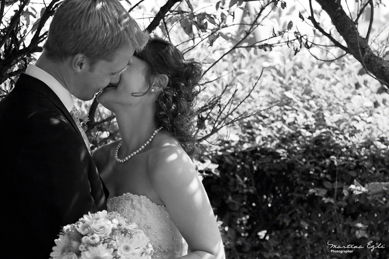 Newlyweds kiss each other.