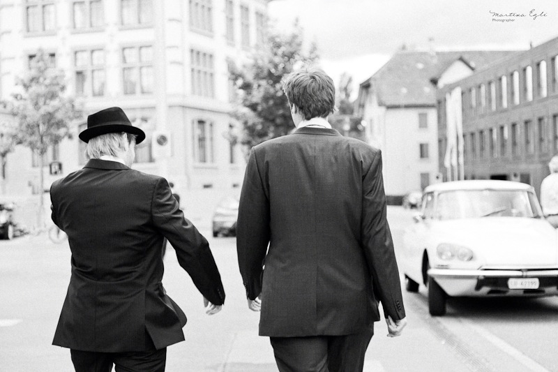 The groom and best man walk down the street.