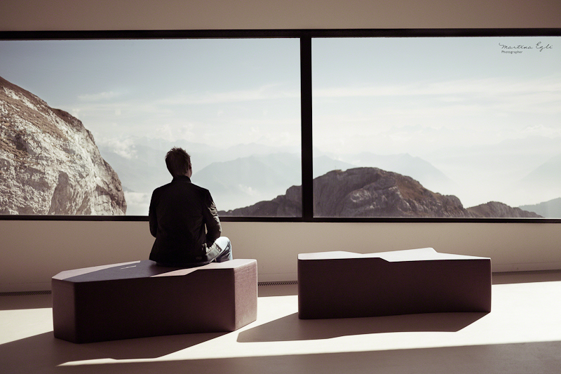 A man looks out upon the Swiss alps from the peak of mount Pilatus.