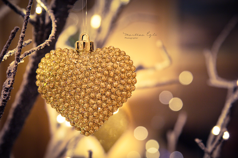 A golden heart hanging on a tree as a Christmas decoration.