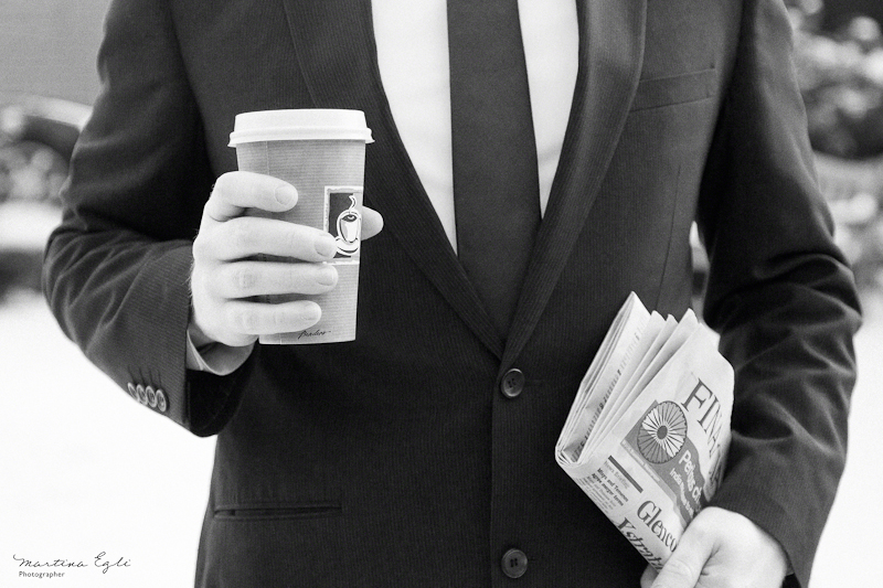 A b&w image of a man in a suit holding a coffee to go and the financial times.