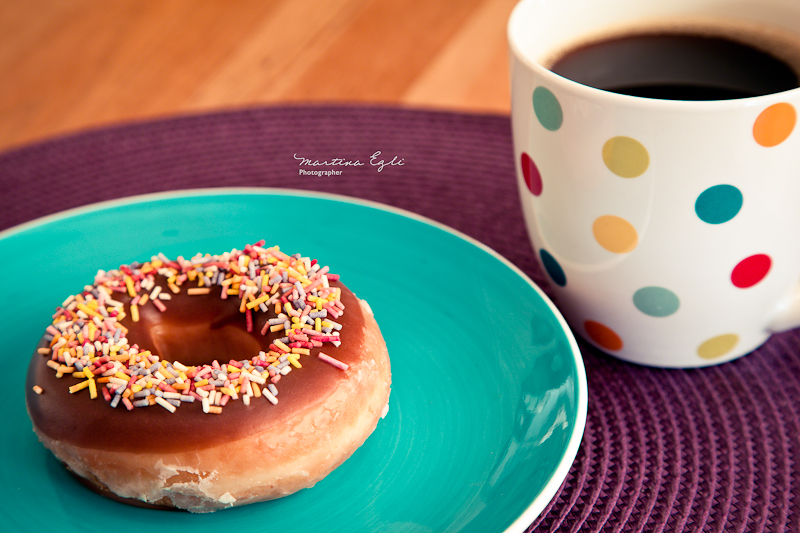 A cup of coffee and a doughnut.