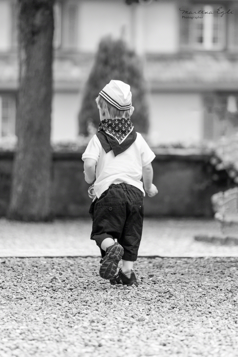 A young boy, dressed as a sailor enjoys his freedom.