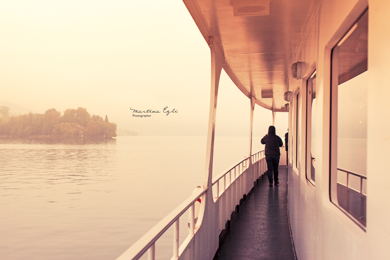 A woman is walking on a boat at sunset.